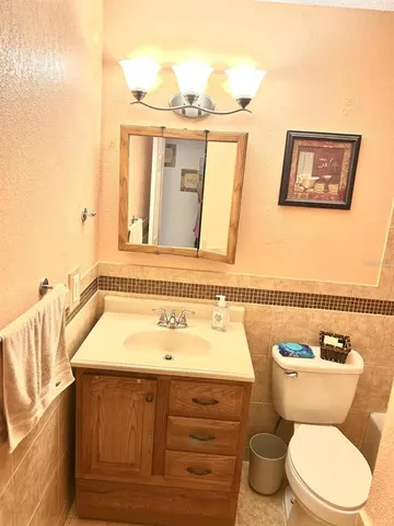 a bathroom with a toilet a sink and mirror