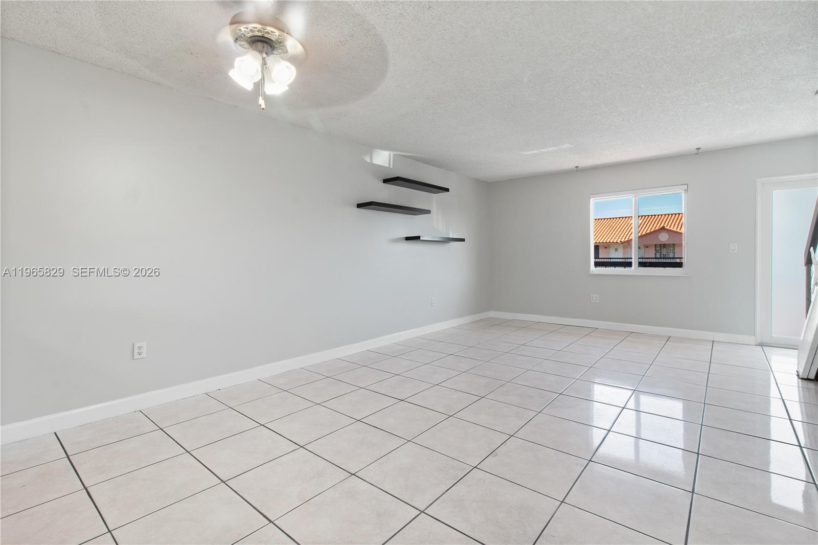2162 West 60th Street, Unit 14203 Hialeah, FL 33016 - Photo 5 of 23 an empty room with windows and ceiling fan