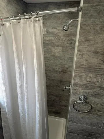 an empty room with wooden floor cabinet and windows