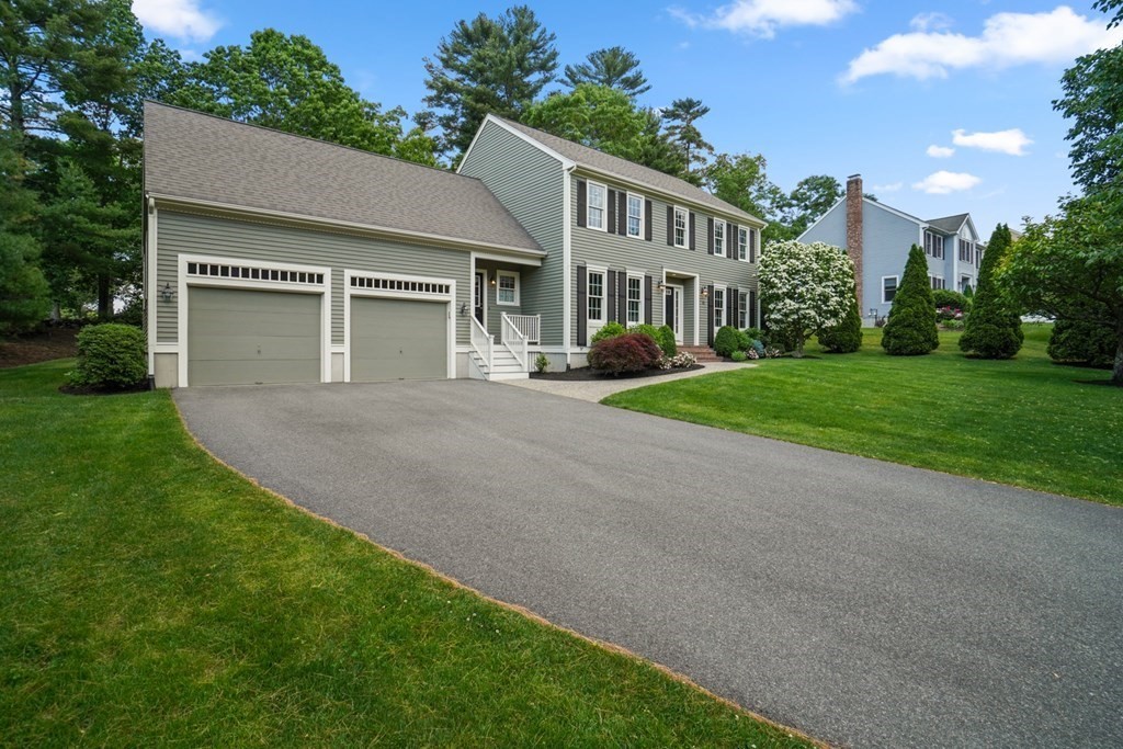 a view of a house with a yard and potted plants