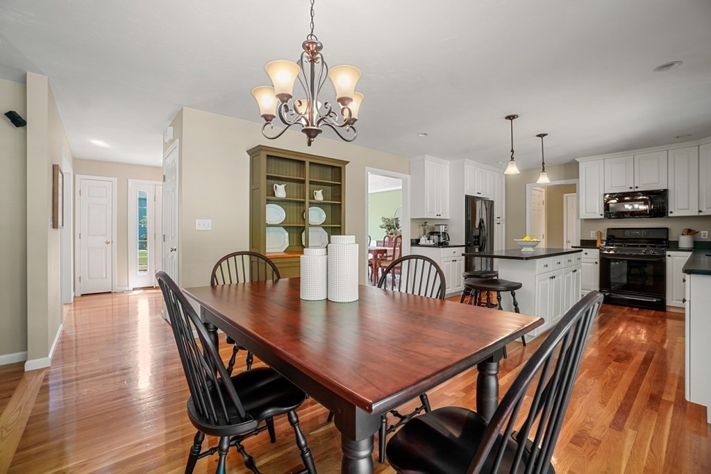 10 Sullivan Way Canton, MA 02021 - Photo 13 of 42 a view of a dining room with furniture a chandelier and wooden floor