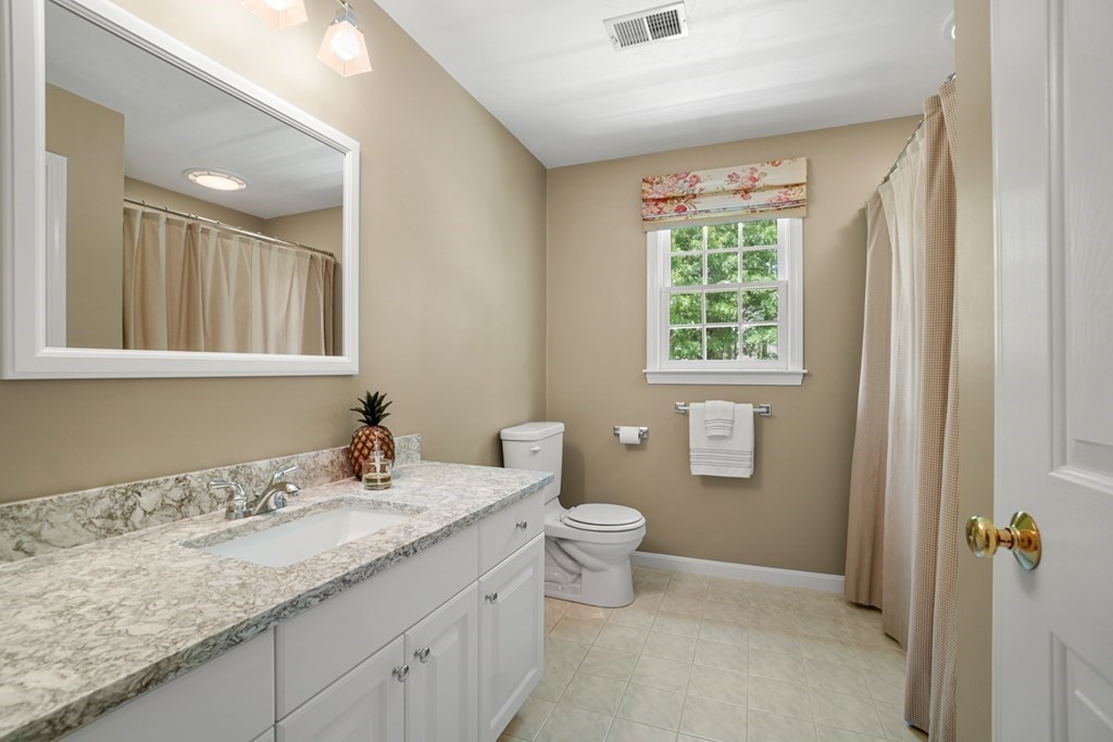 10 Sullivan Way Canton, MA 02021 - Photo 27 of 42 a bathroom with a granite countertop sink a toilet and a window