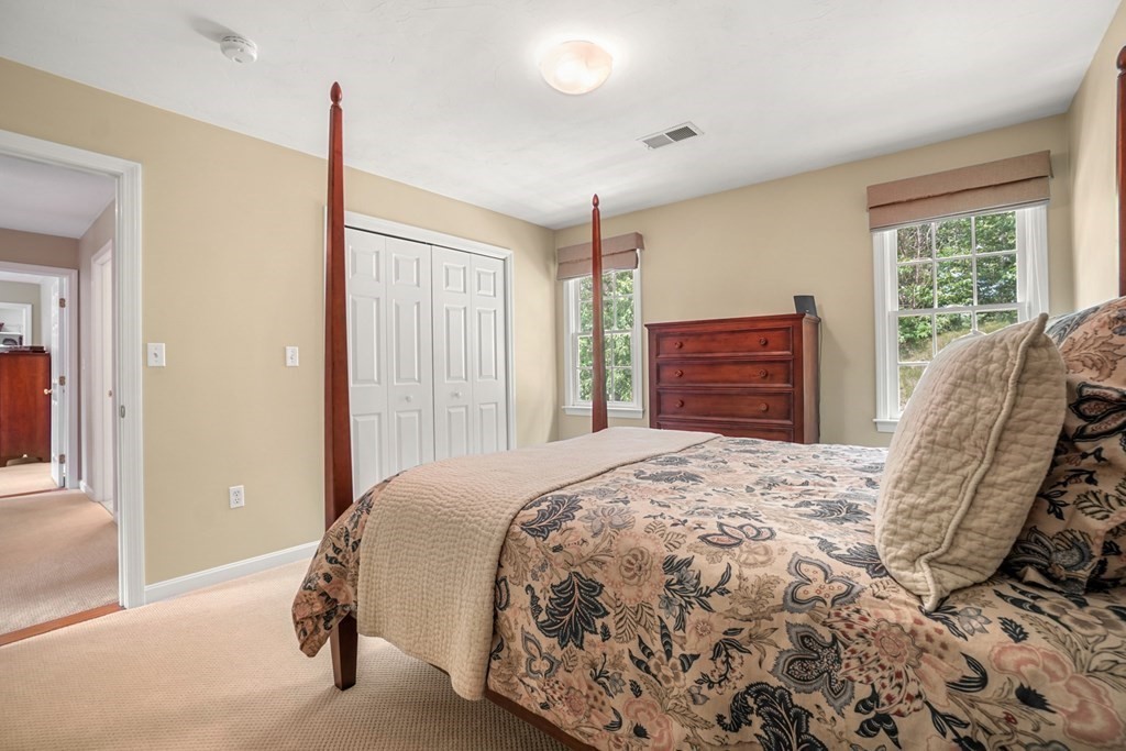 10 Sullivan Way Canton, MA 02021 - Photo 32 of 42 a bedroom with a bed and dresser with mirror