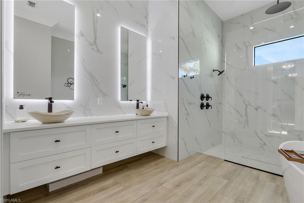 530 1st Street Northwest Naples, FL 34120 - Photo 16 of 35 a bathroom with a double vanity sink a toilet and shower
