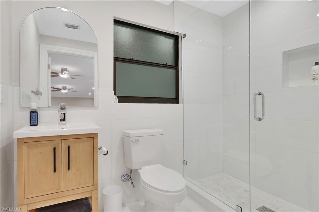 530 1st Street Northwest Naples, FL 34120 - Photo 35 of 35 a bathroom with a toilet a sink a vanity and mirror