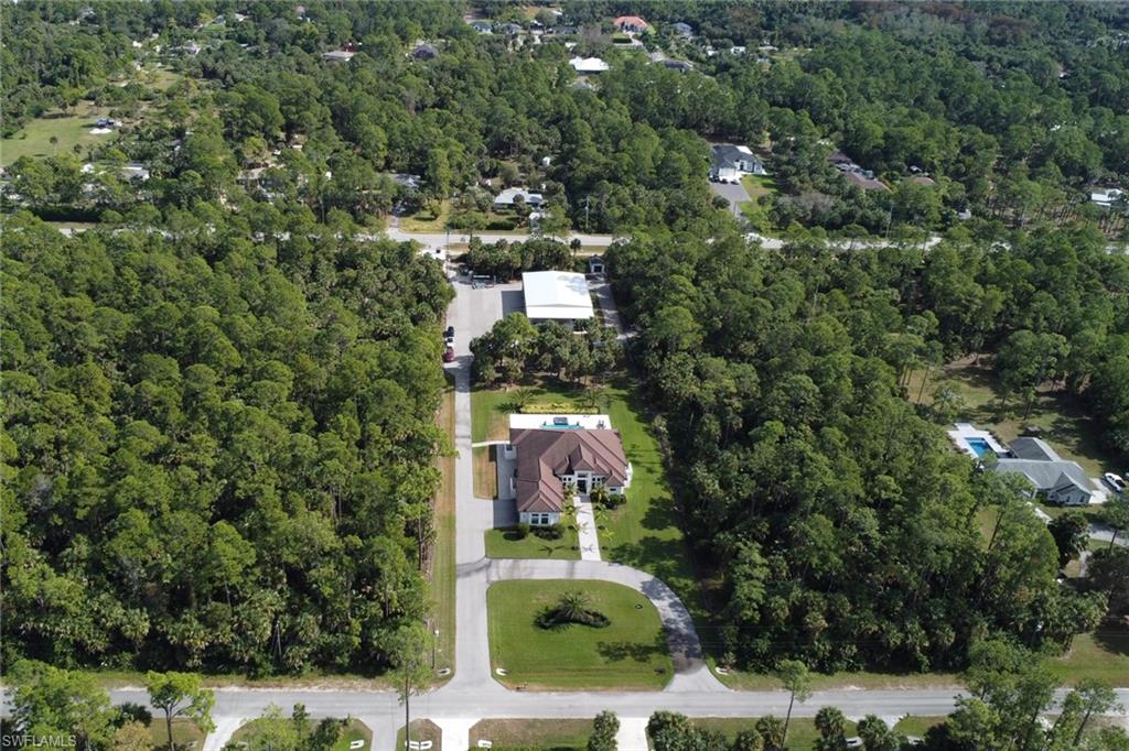 530 1st Street Northwest Naples, FL 34120 - Photo 5 of 35 an aerial view of a house with a yard and large trees