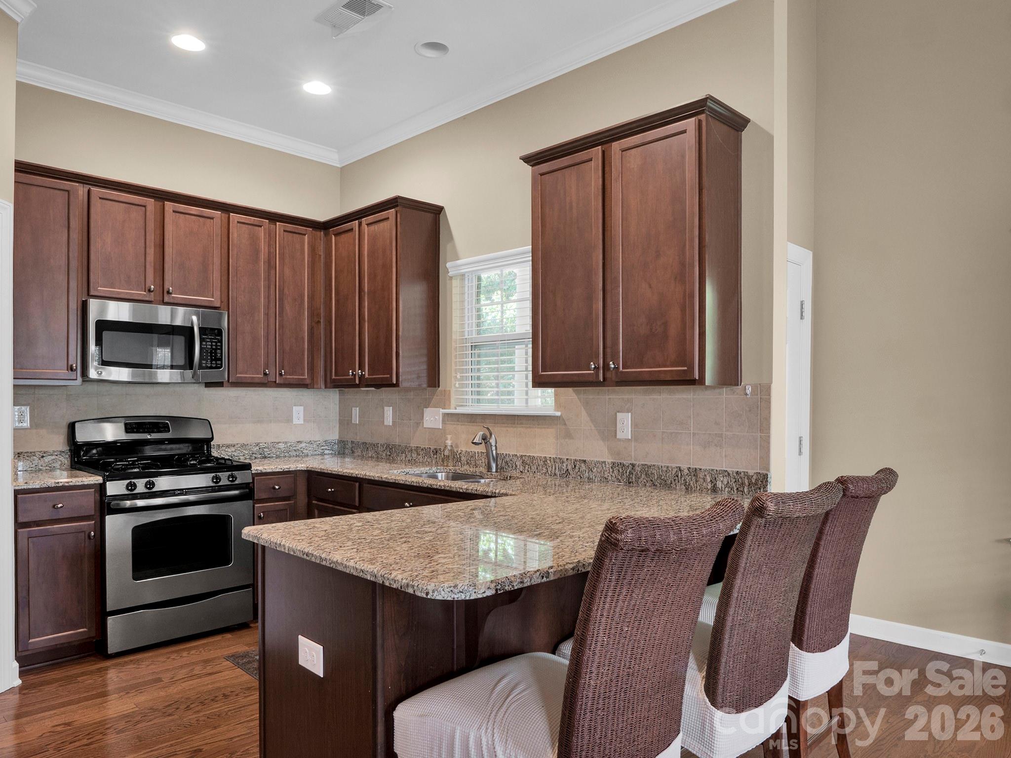 14726 Intermilan Way Charlotte, NC 28277 - Photo 10 of 38 a kitchen with stainless steel appliances granite countertop a table chairs sink and cabinets