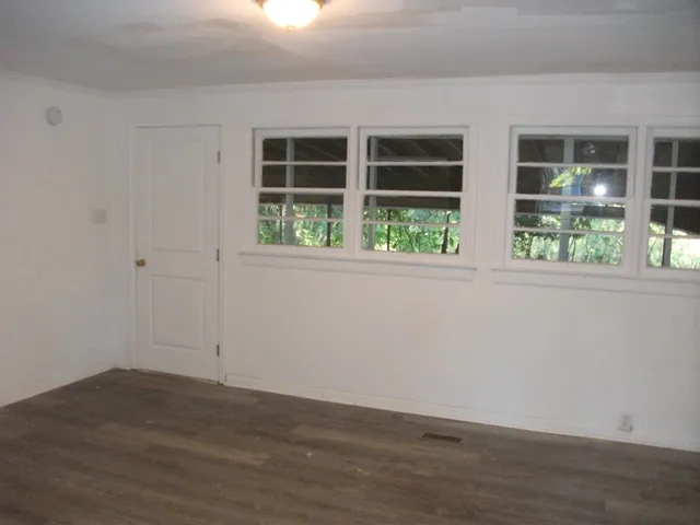 a view of empty room with wooden floor and windows