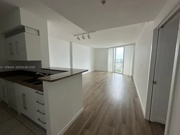 a kitchen with granite countertop a sink and a refrigerator