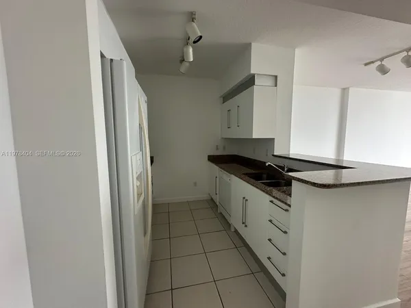 a kitchen with a refrigerator and a sink