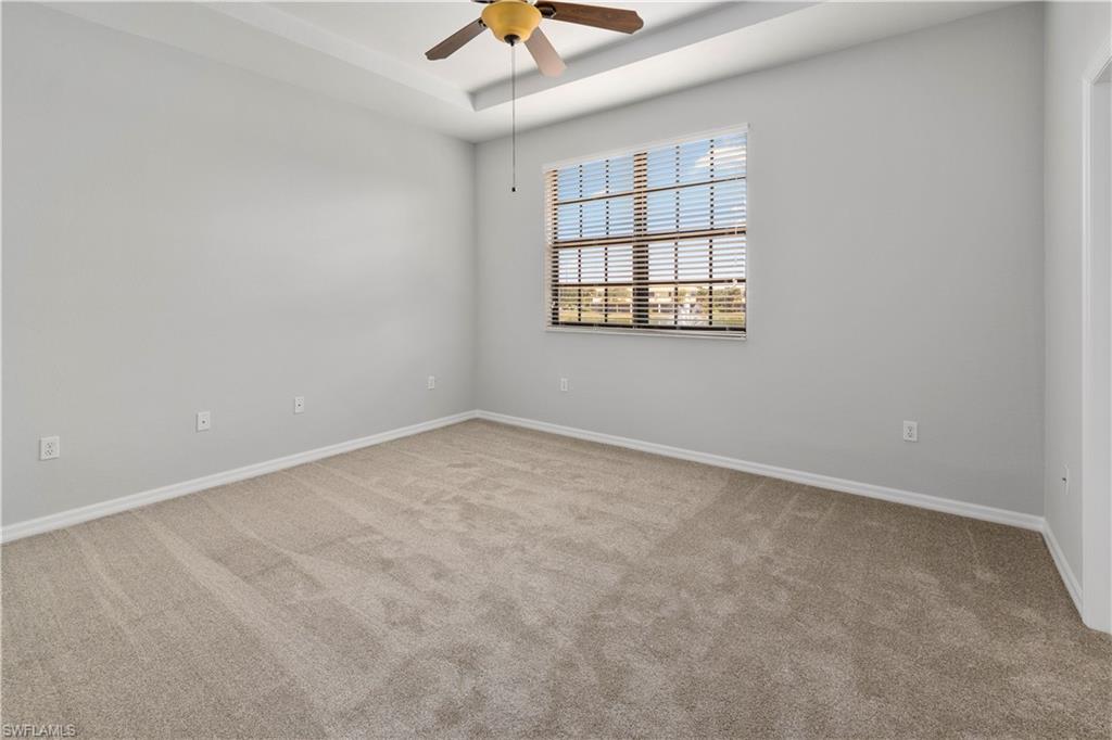 15243 Summit Pl Circle, Unit 247 Naples, FL 34119 - Photo 7 of 18 an empty room with a window and a ceiling fan