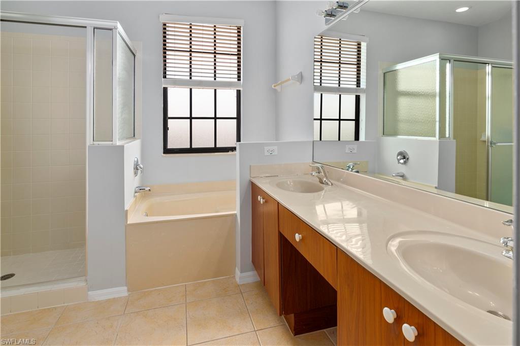 15243 Summit Pl Circle, Unit 247 Naples, FL 34119 - Photo 8 of 18 a bathroom with a granite countertop sink mirror bathtub and shower