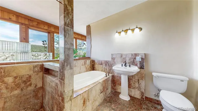 a bathroom with a tub toilet and a sink