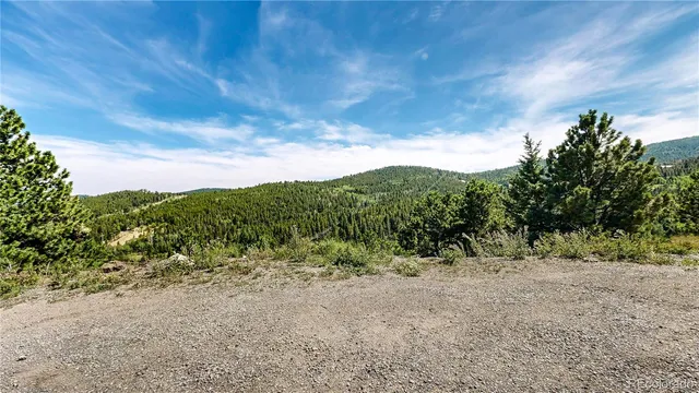 an aerial view of a house with a yard and mountain view in back