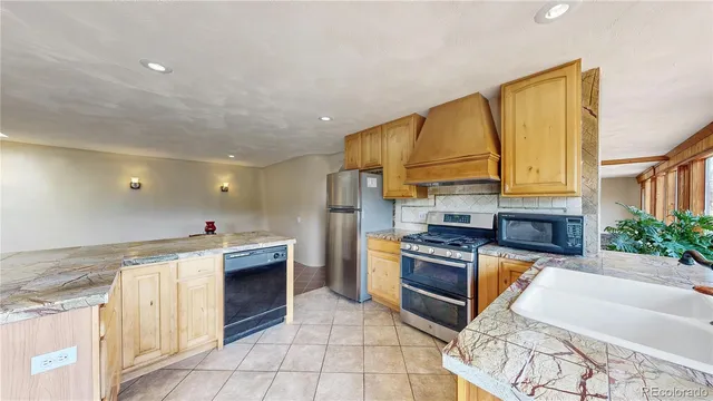 a kitchen with granite countertop a sink stainless steel appliances and cabinets