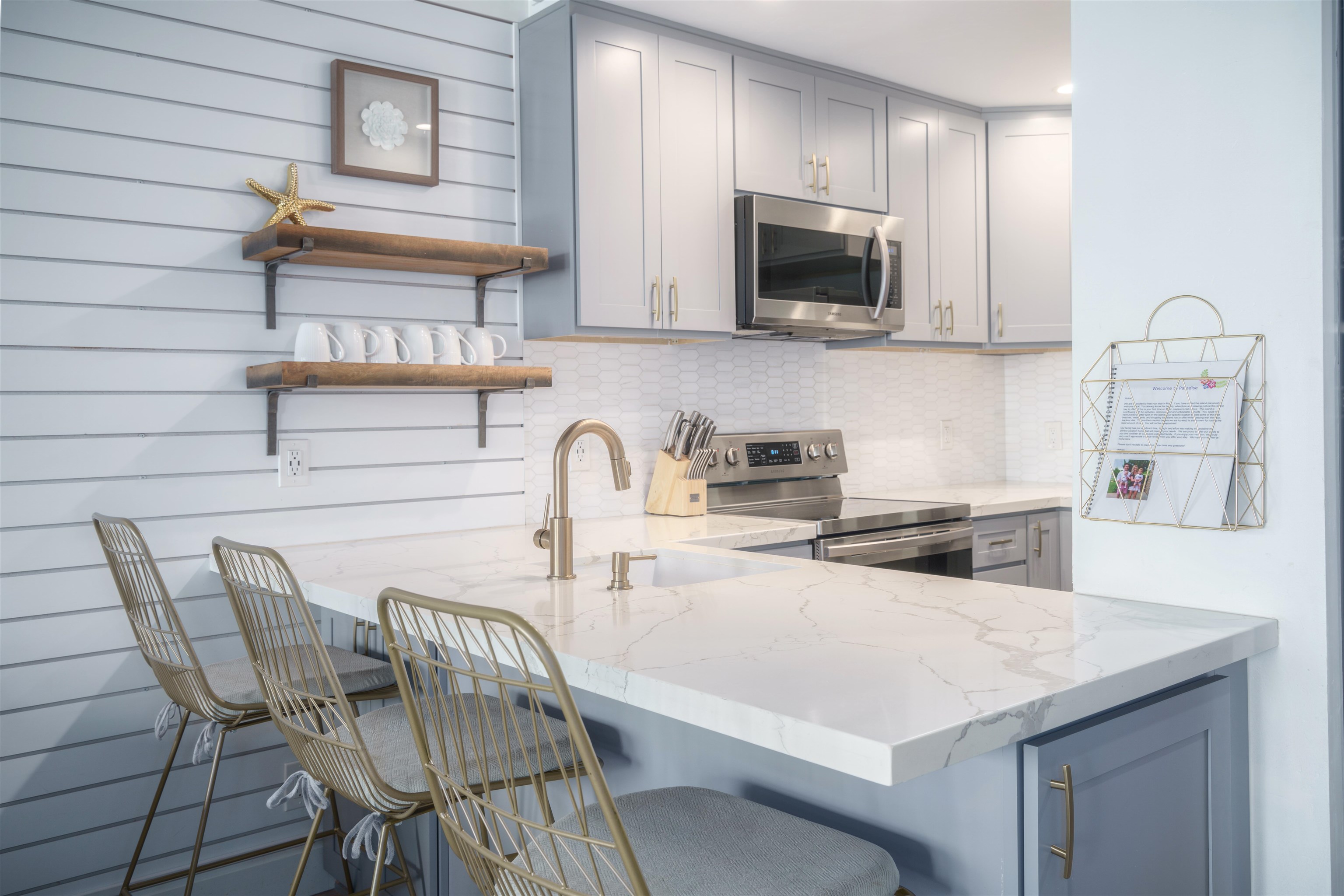 3741 Lower Honoapiilani Road, Unit 303 Lahaina, HI 96761 - Photo 3 of 30 a kitchen with stainless steel appliances granite countertop a kitchen island a stove a sink a table and chairs