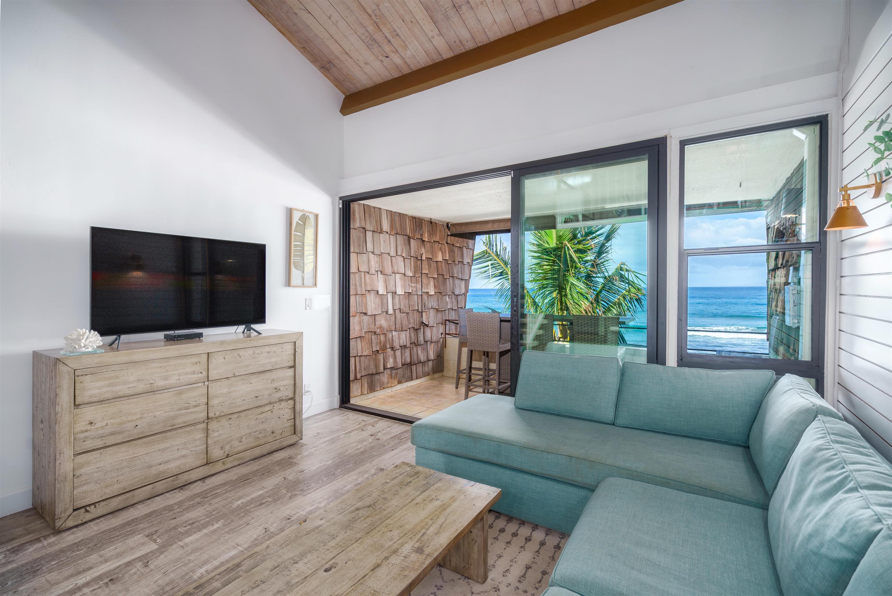 3741 Lower Honoapiilani Road, Unit 303 Lahaina, HI 96761 - Photo 5 of 30 a living room with furniture a flat screen tv and a flat screen tv