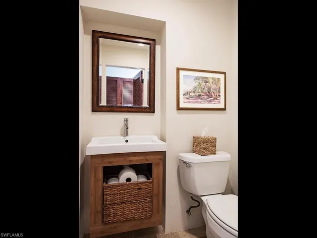 a bathroom with a toilet a sink and mirror