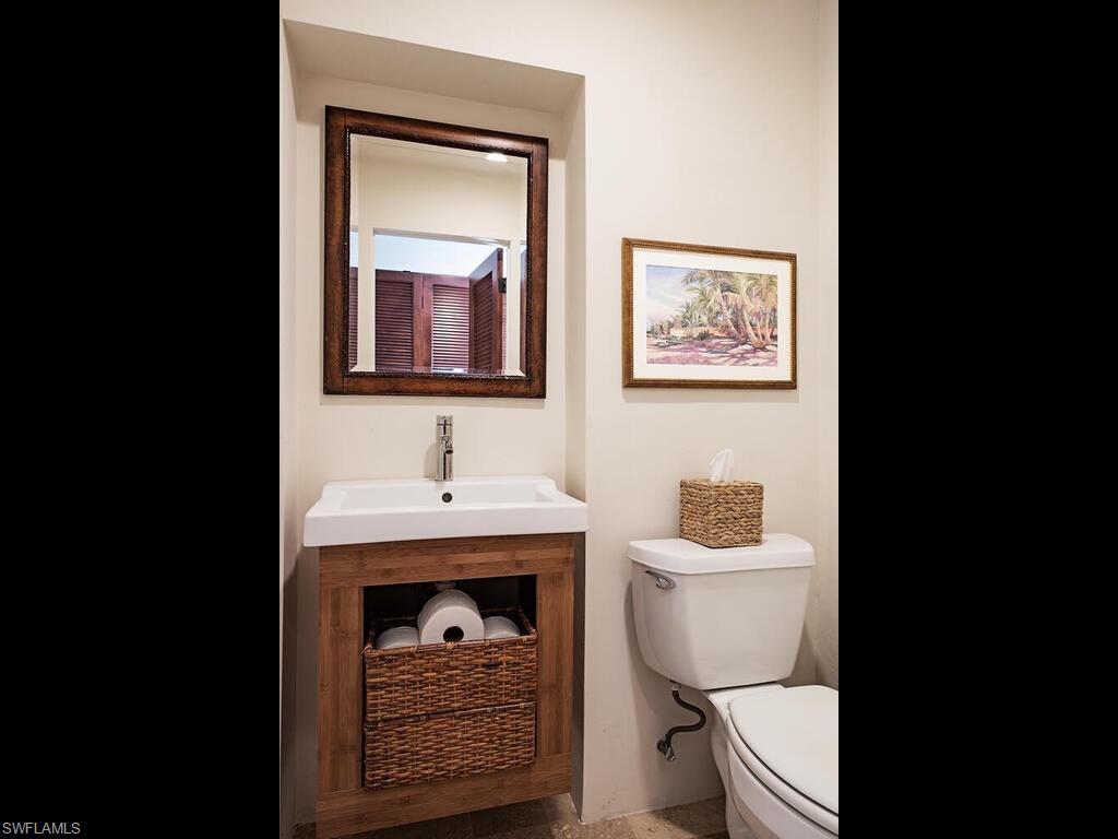 1200 9th Avenue North Naples, FL 34102 - Photo 13 of 22 a bathroom with a toilet a sink and mirror