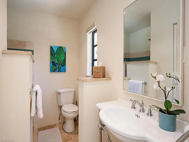 a bathroom with a toilet sink and mirror