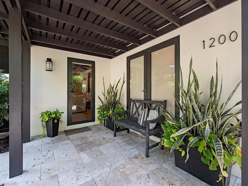 1200 9th Avenue North Naples, FL 34102 - Photo 3 of 22 a porch with chairs and potted plants