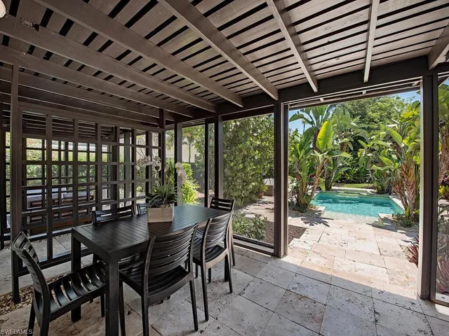a dining room with furniture and a garden view