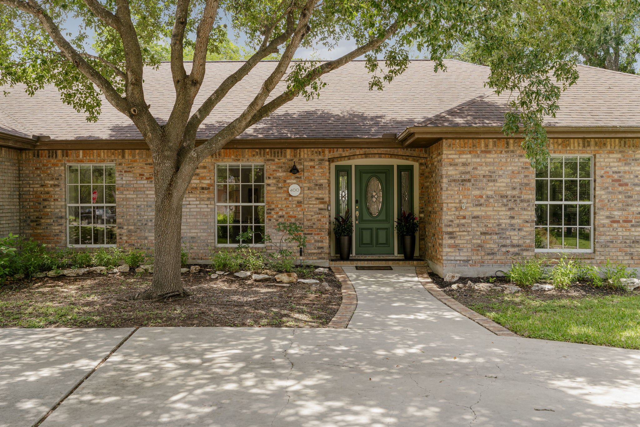 400 Hackberry Street Lockhart, TX 78644 - Photo 33 of 40 A classic brick exterior with a verdant front door welcomes all to this charming residence.