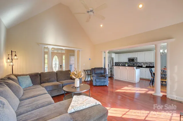 a kitchen with stainless steel appliances a dining table chairs a refrigerator and cabinets