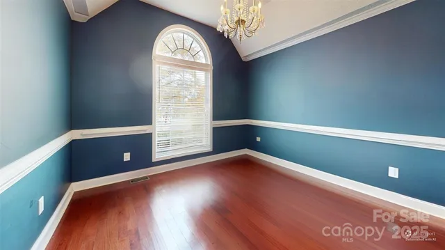 a spacious bedroom with a bed and a chandelier