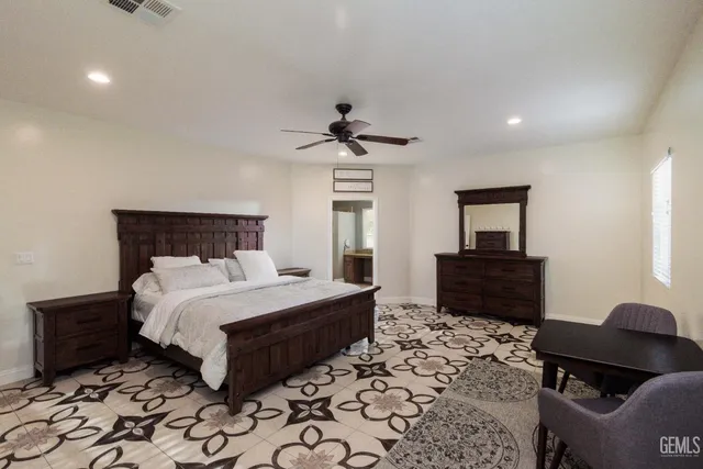 a en suite bathroom with a granite countertop sink and a window