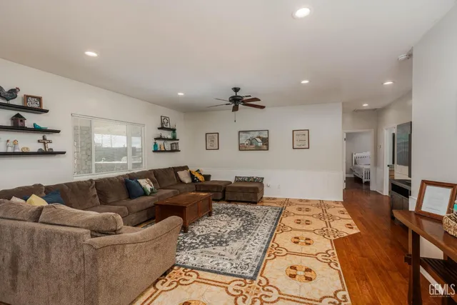 a kitchen with stainless steel appliances granite countertop a stove top oven a sink dishwasher a dining table and chairs with wooden floor