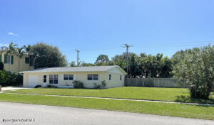 317 3rd Avenue Indialantic, FL 32903 - Photo 14 of 18 a front view of a house with a garden and trees