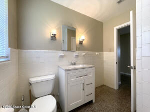 317 3rd Avenue Indialantic, FL 32903 - Photo 7 of 18 a bathroom with a granite countertop toilet sink and mirror