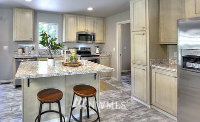 16029 Gibson Road Southwest Tenino, WA 98589 - Photo 19 of 35 a kitchen with granite countertop a counter space cabinets stainless steel appliances and a center island