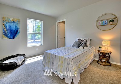 16029 Gibson Road Southwest Tenino, WA 98589 - Photo 22 of 35 a bedroom with a bed and a chandelier