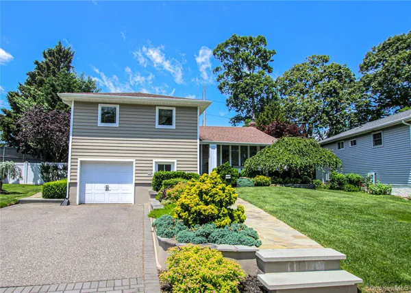 a front view of a house with a yard and a garage