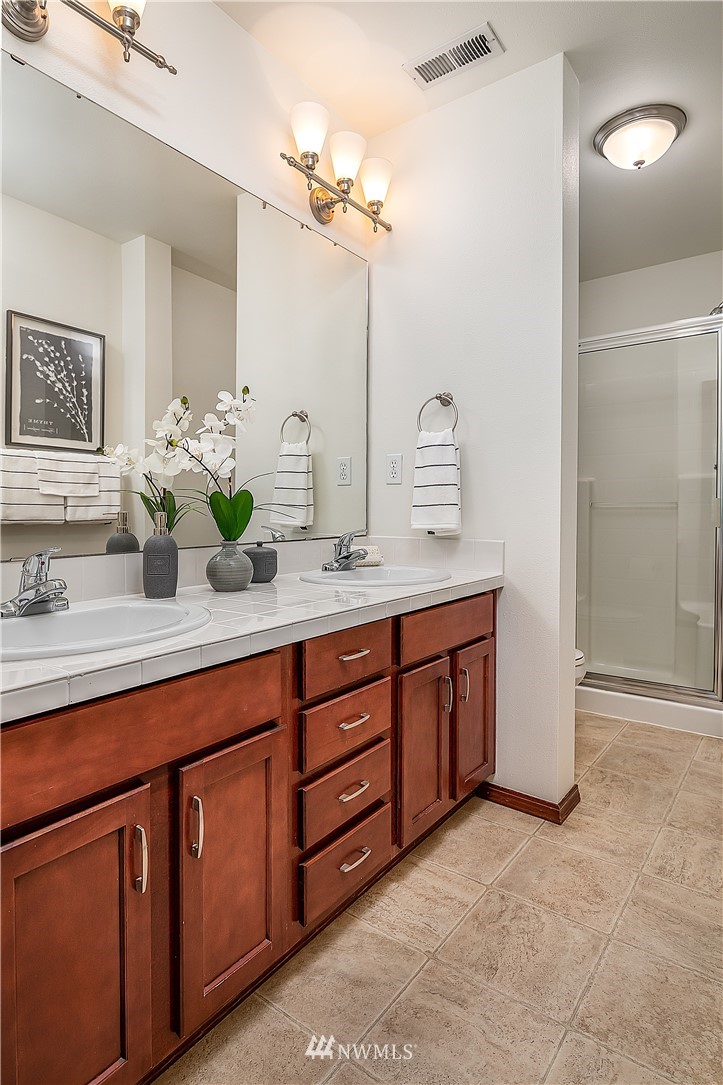 1043 215th Place Southeast Bothell, WA 98021 - Photo 17 of 29 a bathroom with a granite countertop double vanity sink and a mirror
