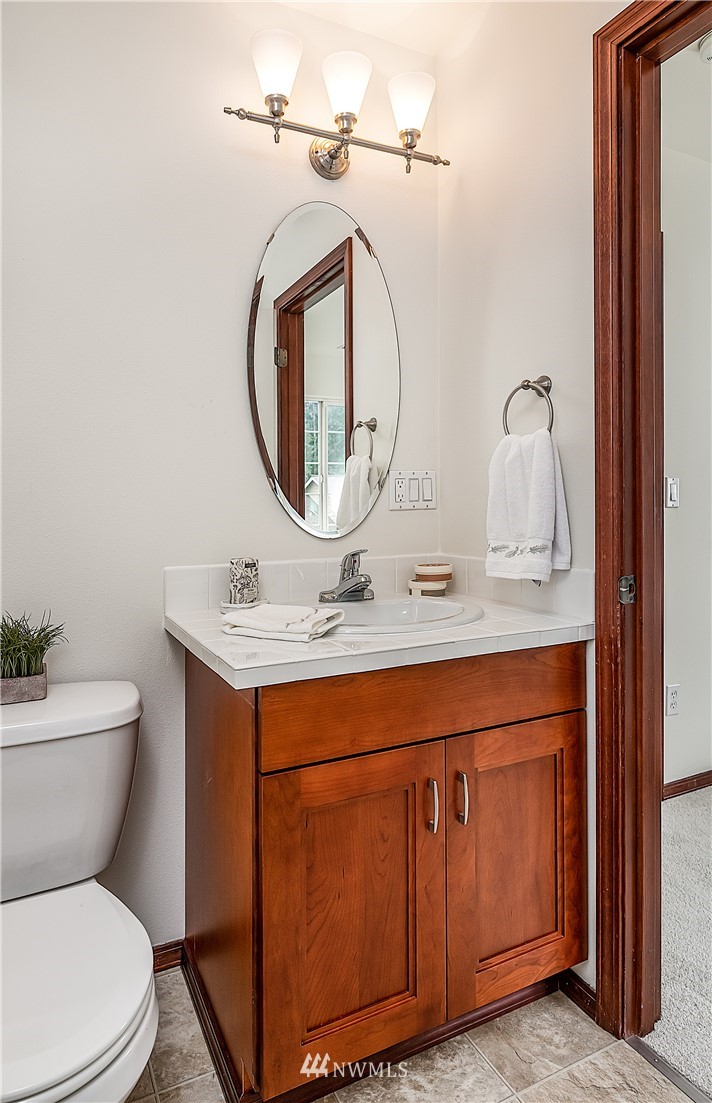 1043 215th Place Southeast Bothell, WA 98021 - Photo 21 of 29 a bathroom with a granite countertop toilet sink and mirror