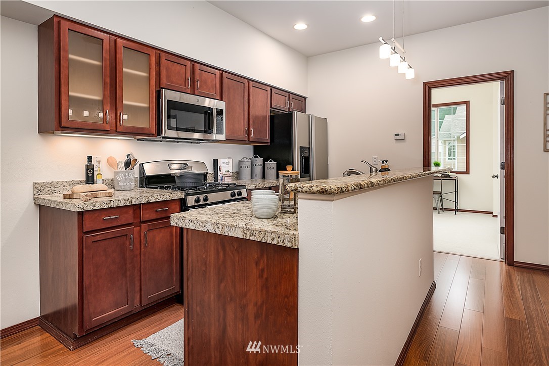 1043 215th Place Southeast Bothell, WA 98021 - Photo 9 of 29 a kitchen with stainless steel appliances granite countertop a sink stove and microwave