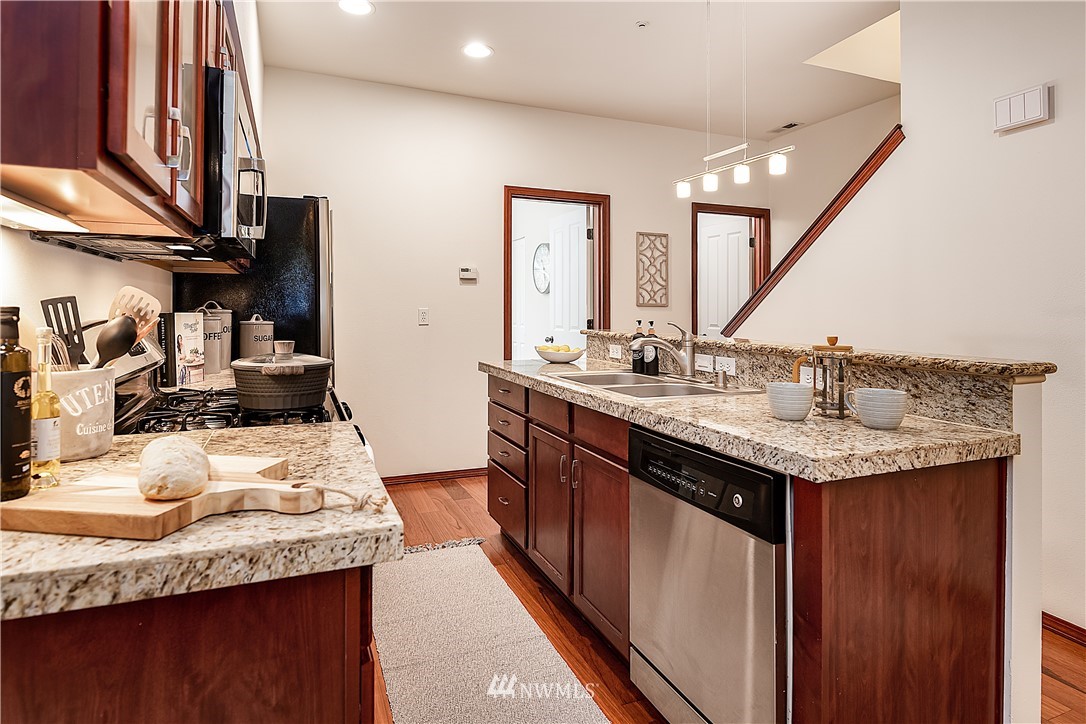 1043 215th Place Southeast Bothell, WA 98021 - Photo 10 of 29 a kitchen with stainless steel appliances granite countertop a sink stove and cabinets