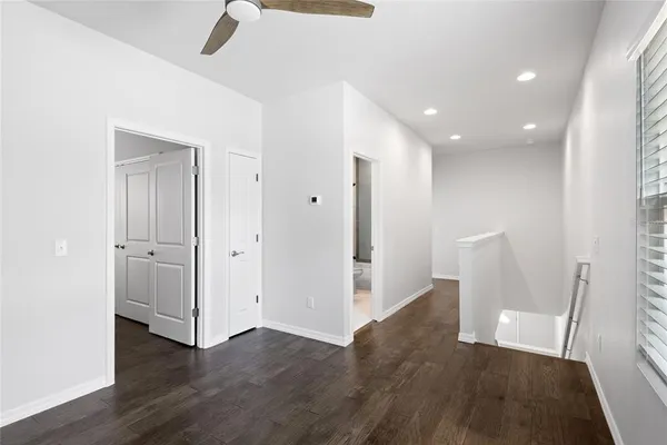 a view of a hallway with wooden floor and chair