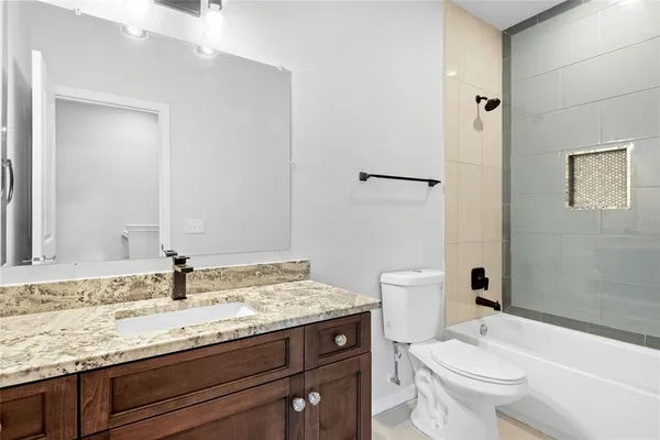a bathroom with a granite countertop sink toilet and shower