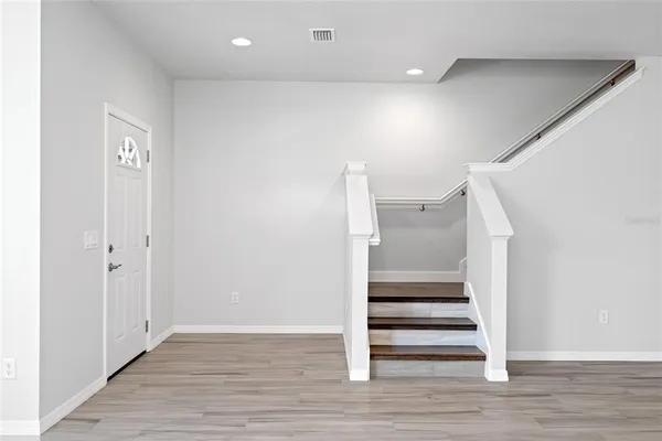 a view of entryway and hall with wooden floor