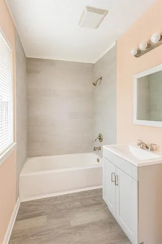 a bathroom with a bathtub a sink a window and a shower