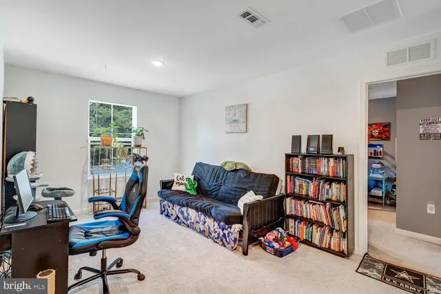 a living room with furniture and a book shelf