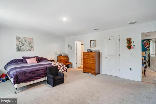 a spacious bedroom with a bed and a walk in closet