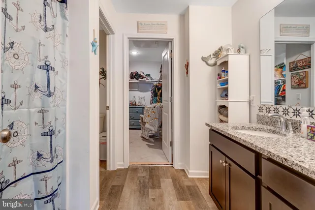 a bathroom with a granite countertop shower sink and mirror