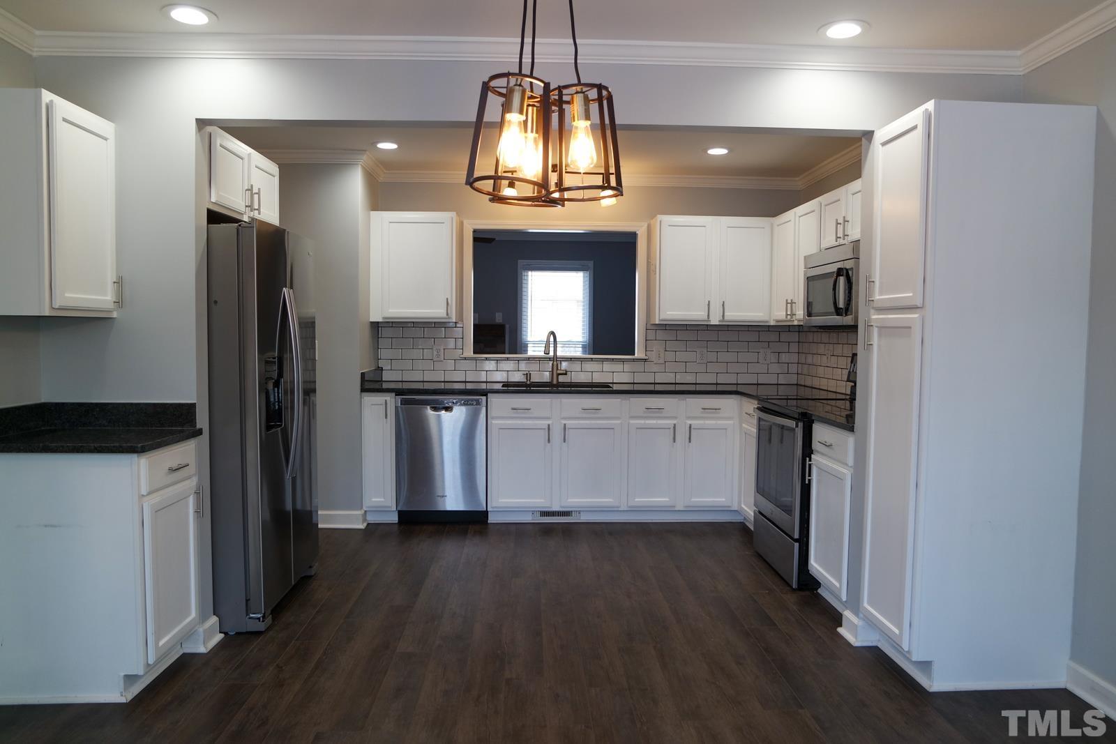 3800 Axle Lane Raleigh, NC 27616 - Photo 4 of 11 a kitchen with granite countertop a stove refrigerator and microwave