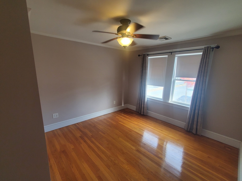1 Grayson Street, Unit 2 Boston, MA 02124 - Photo 15 of 23 a view of an empty room with wooden floor and a window
