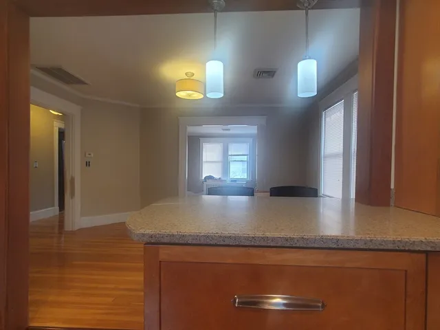 a view of kitchen island a sink wooden floor and a living room view